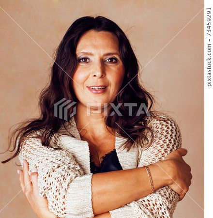 pretty brunette confident mature woman posing cheerful on warm brown background, lifestyle people concept pretty brunette confident mature woman posing cheerful on warm brown background, lifestyle people concept 73459291