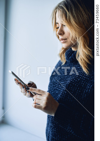 Close-up of a girl's hands with a mobile phone with a black screen. Close-up of a girl's hands with a mobile phone with a black screen. 73459660