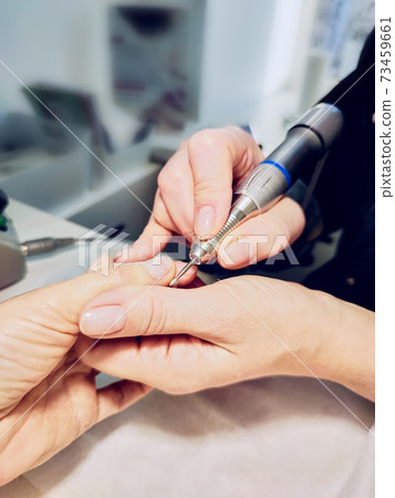 Closeup of a woman's hands in a nail salon getting a manicure Closeup of a woman's hands in a nail salon getting a manicure 73459661