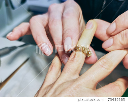 Closeup of a girl's hands in a nail salon. piral for finger massage. Closeup of a girl's hands in a nail salon. piral for finger massage. 73459665