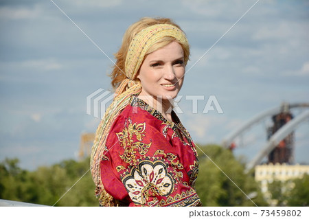 A woman in 1960 hippie style clothes poses outdoors A woman in 1960 hippie style clothes poses outdoors 73459802