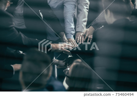 through the blinds. business team showing their unity. through the blinds. business team showing their unity. 73460494