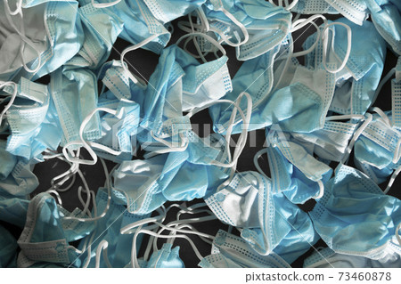 Texture of wrinkled protective face masks, discarded dirty trash. 73460878