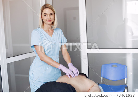 The doctor massages the man in the hospital 73461658