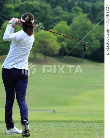 Woman hitting the tee shot Woman hitting the tee shot 73461727