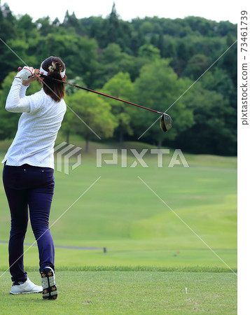Woman hitting the tee shot Woman hitting the tee shot 73461739