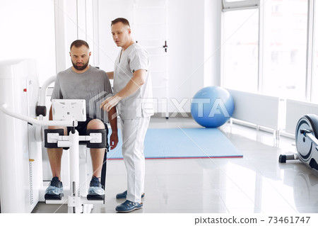 Doctor with a patient in physiotherapy clinic Doctor with a patient in physiotherapy clinic 73461747