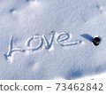 Word Love written on snow during the sunny day. Thermo cup in snow. Love to winter days, walking and snowy weather. Valentines day sign. 73462842