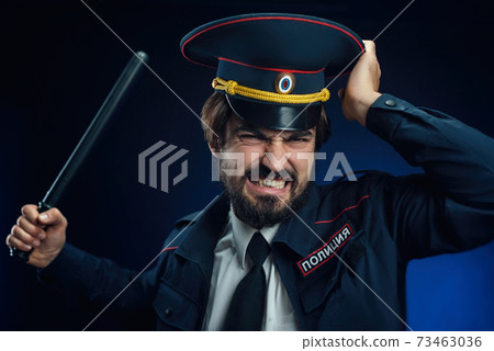 a man in a Russian police uniform with a baton. English translation of " Police" a man in a Russian police uniform with a baton. English translation of " Police" 73463036
