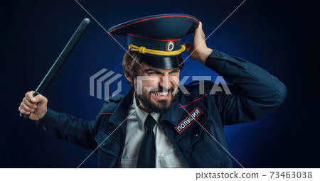 a man in a Russian police uniform with a baton. English translation of " Police" 73463038