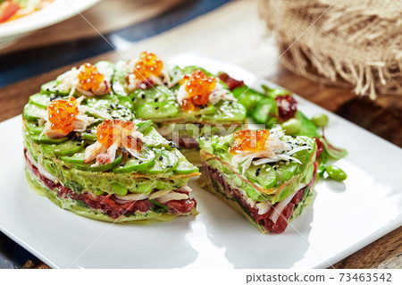 Salad of avokado, seafood, meat, vegetables and pumpkin seeds. Dietary, wholesome and tasty. Banquet festive dishes. Gourmet restaurant menu. White background. Salad of avokado, seafood, meat, vegetables and pumpkin seeds. Dietary, wholesome and tasty. Banquet festive dishes. Gourmet restaurant menu. White background. 73463542