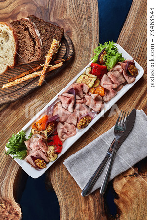 Sliced Beef or Pork with Marinated Vegetables and Sauce. Beautifully decorated catering banquet menu. Food snacks and appetizers for buffet on white background Sliced Beef or Pork with Marinated Vegetables and Sauce. Beautifully decorated catering banquet menu. Food snacks and appetizers for buffet on white background 73463543
