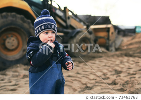 A little boy that is standing in the sand 73463768