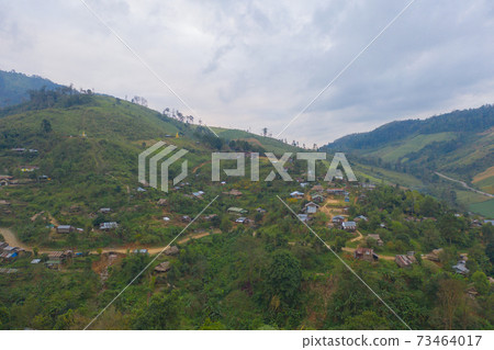 Aerial top view of immigrant refugees residential village houses in countryside, rural area. Local community houses in urban town near natural forest on mountain hills, Tak, Thailand. Evacuation. Aerial top view of immigrant refugees residential village houses in countryside, rural area. Local community houses in urban town near natural forest on mountain hills, Tak, Thailand. Evacuation. 73464017