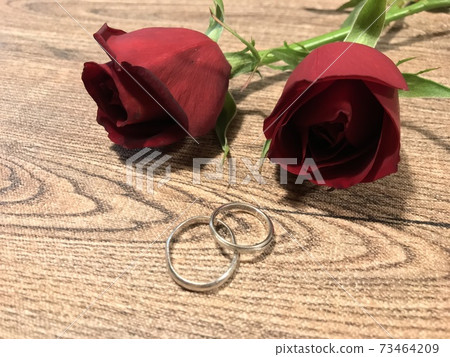 紅玫瑰和結婚戒指放在木桌，婚姻，訂婚，婚姻活動圖像 73464209
