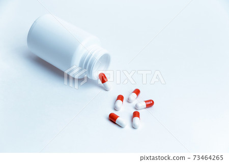 capsules with medicine and a bottle on a white background. capsules with medicine and a bottle on a white background. 73464265