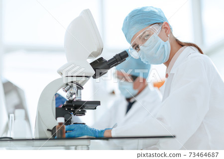 scientists testing the liquid and writing the results in a laboratory journal. 73464687