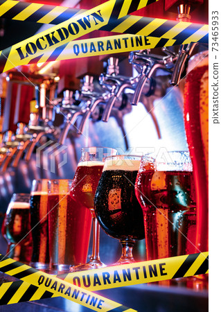 Glasses of different types of beer at bar with bounding tapes Lockdown, Coronavirus, Quarantine, Warning - closing bars and nightclubs during pandemic Glasses of different types of beer at bar with bounding tapes Lockdown, Coronavirus, Quarantine, Warning - closing bars and nightclubs during pandemic 73465933