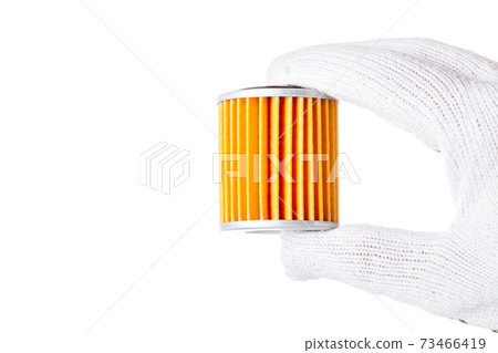 Car filter orange color in hand isolated on white background with empty copy space for text. 73466419