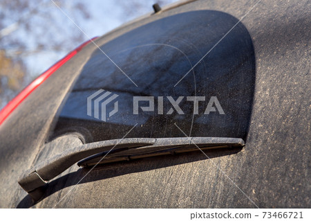 Close up of a dirty car wiper on a dirty back window in mud and divorce. 73466721