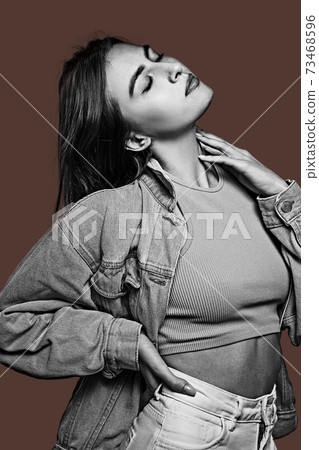 Black and white portrait of young beautiful girl isolated on dark background. 73468596