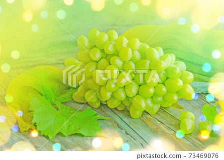 White wine grapes. Grapes on a wooden table. 73469076