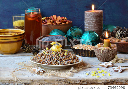 Candied orange in the shape of a star on dessert Kutia. Uzvar drink with dried fruits for ukrainian Christmas. 73469098