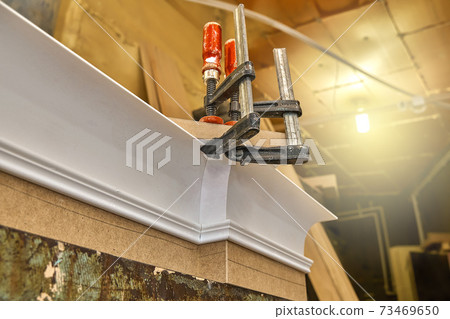Joinery. Crown molding. Home library with classic design. Wooden furniture manufacturing process 73469650