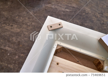 Joinery. Crown molding. Home library with classic design. Wooden furniture manufacturing process Joinery. Crown molding. Home library with classic design. Wooden furniture manufacturing process 73469651