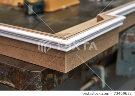 Joinery. Crown molding. Home library with classic design. Wooden furniture manufacturing process Joinery. Crown molding. Home library with classic design. Wooden furniture manufacturing process 73469652