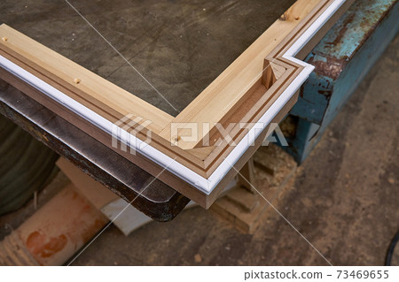 Joinery. Crown molding. Home library with classic design. Wooden furniture manufacturing process Joinery. Crown molding. Home library with classic design. Wooden furniture manufacturing process 73469655