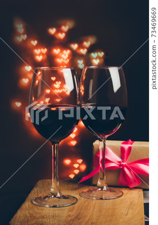 Two wine glasses on a parkling heart shape backdrop 73469669