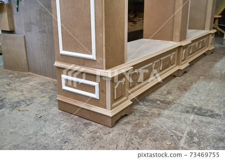 Joinery. Mdf cabinet carcass with moldings and decor. Wooden furniture manufacturing process 73469755