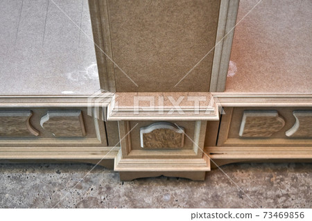Joinery. Mdf cabinet carcass with moldings and decor. Wooden furniture manufacturing process 73469856