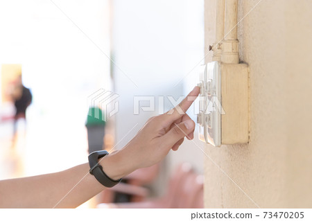 Close up young man's hand pressed the button to turn on the light switch, Open the electrical circuit beside the wall. Close up young man's hand pressed the button to turn on the light switch, Open the electrical circuit beside the wall. 73470205