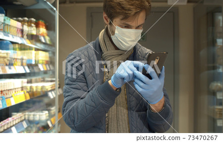 Young man looking in smartphone in the store Young man looking in smartphone in the store 73470267