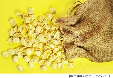 Pasta orecchiette on a colored background 73472381