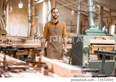 Portrait of a handsome carpenter at the joiner's shop 73472694