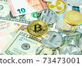 Various cryptocurrency coins on paper dollar and euro banknotes. Bitcoin, ethereum, litecoin and others modern virtual currency 73473001