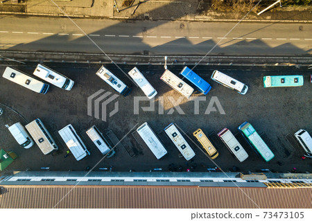 Aerial view of many cars and buses moving on a busy city street. 73473105