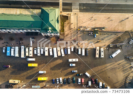 Aerial view of many cars and buses moving on a busy city street in front of railway station building in Ivano-Frankivsk city, Ukraine. 73473106