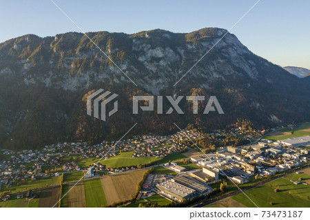Aerial view of green meadows with villages and forest in austrian Alps mountains. 73473187