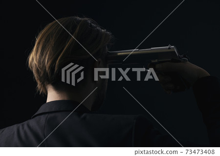 Back view of male victim with gun near temple 73473408