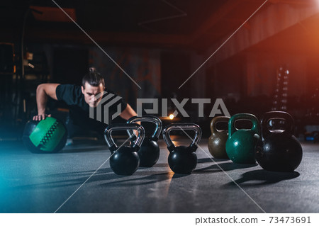 young man has crossfit workout with weight in gym 73473691