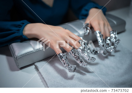closeup shot and manicure artist making nail cleaning and polishing closeup shot and manicure artist making nail cleaning and polishing 73473702