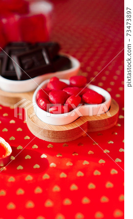 Chocolates and sweets on heart-shaped plates. Festive table setting for date Chocolates and sweets on heart-shaped plates. Festive table setting for date 73473897