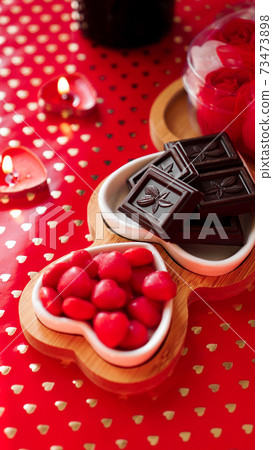 Chocolates and sweets on heart-shaped plates. Festive table setting for date Chocolates and sweets on heart-shaped plates. Festive table setting for date 73473898