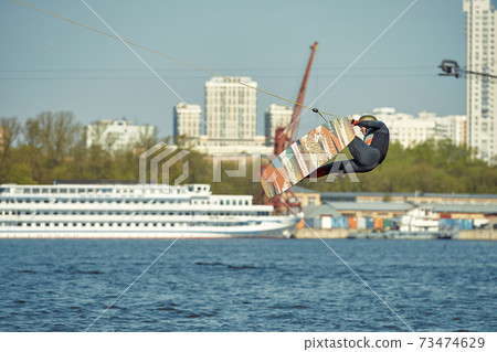 Young man riding wakeboard on a summer lake 73474629