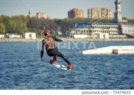 Young man riding wakeboard on a summer lake 73474635