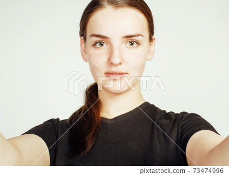 young pretty teenage girl making selfie isolated on white background close up 73474996